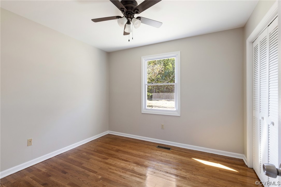 4807 Olgers Road Sutherland, VA 23885 - Photo 17 of 25 an empty room with wooden floor chandelier fan and windows