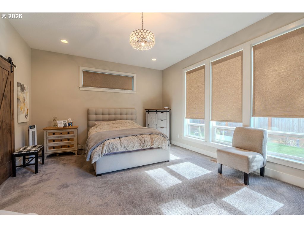 38408 Juniper Street Sandy, OR 97055 - Photo 15 of 47 a spacious bedroom with a bed a couch and a window