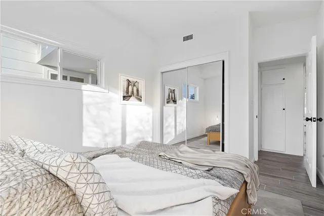 a bedroom with a bed and a large mirror