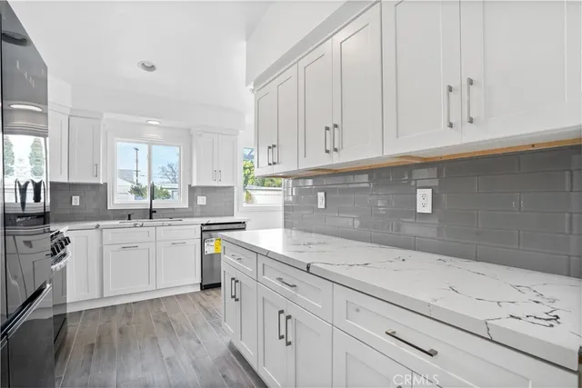 a kitchen with granite countertop white cabinets and white appliances