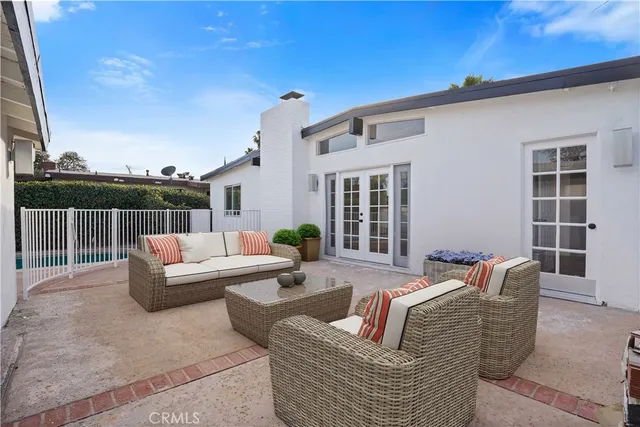 a view of a patio with couches chairs and wooden floor