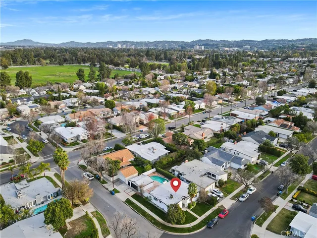 an aerial view of a city with lots of residential buildings ocean and mountain view in back