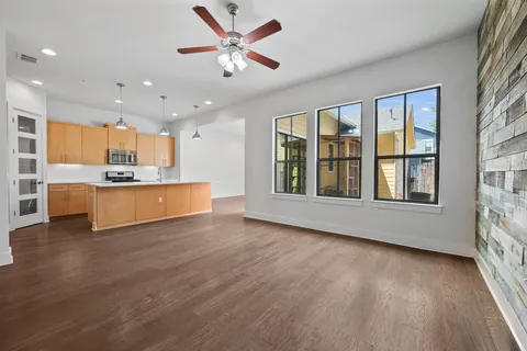 a view of an empty room with window and wooden floor