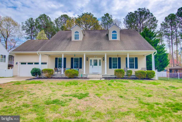 a front view of a house with a yard and outdoor seating