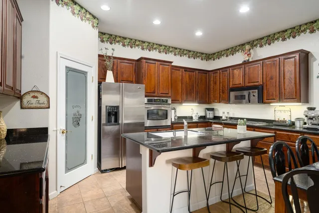 a kitchen with stainless steel appliances granite countertop wooden cabinets a stove top oven a sink and dishwasher