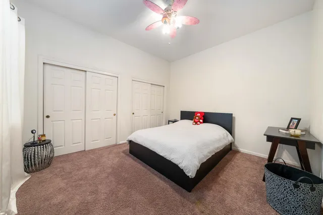 a bedroom with a large bed and a chandelier fan