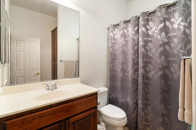 a spacious bedroom with a large bed and a chandelier fan
