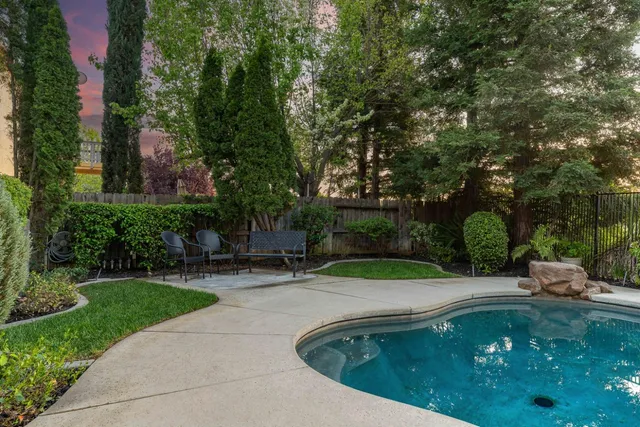 a view of a house with pool and a yard