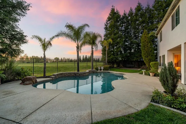 an aerial view of a house with swimming pool and big yard