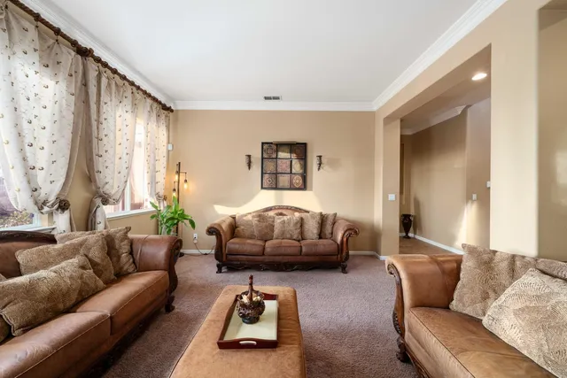 a kitchen with stainless steel appliances kitchen island granite countertop a table chairs and a refrigerator