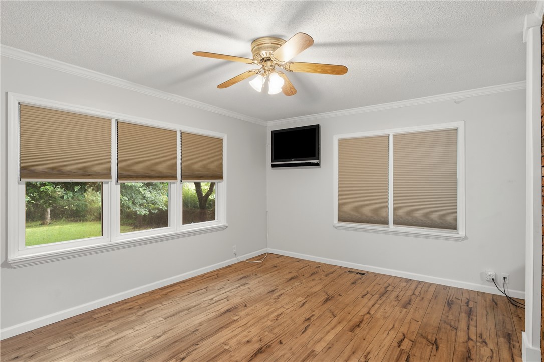 1014 East Queen Street Pendleton, SC 29670 - Photo 22 of 43 Well-lit room with wood flooring, crown molding, and a ceiling fan for comfort.
