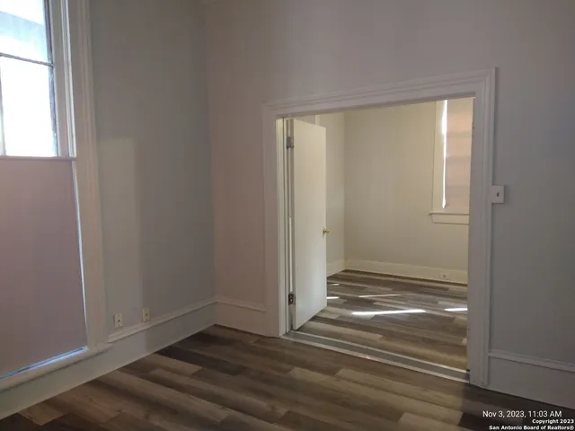a view of empty room with wooden floor