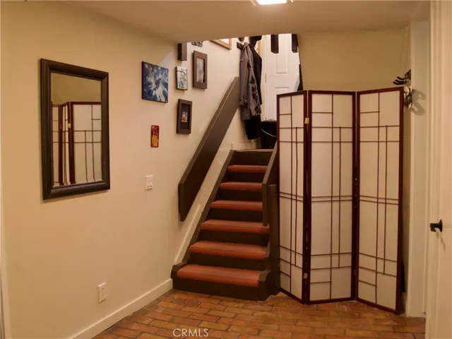 a view of staircase with lots of frames on wall and a window