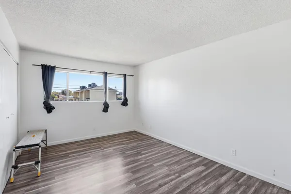 a view of a room with wooden floor and white walls