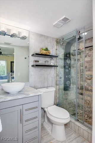 a bathroom with a granite countertop toilet sink and shower