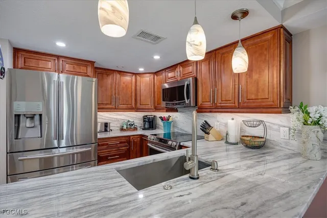 a kitchen with granite countertop wooden cabinets a stove top oven a sink and dishwasher