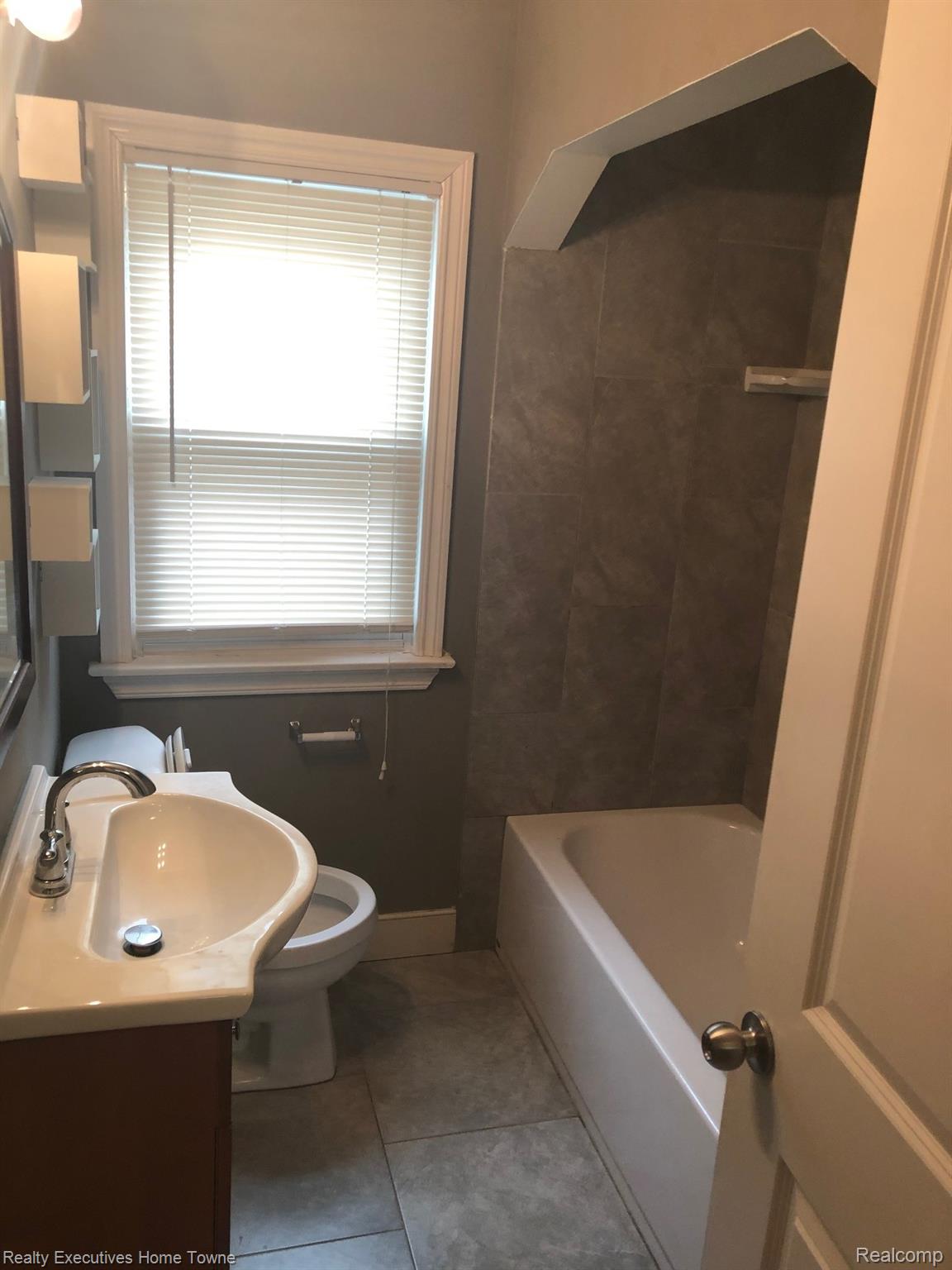 2427 Cambridge Road Berkley, MI 48072 - Photo 12 of 17 Bathroom featuring a white vanity with integrated sink, chrome faucet, and wood-finish cabinetry