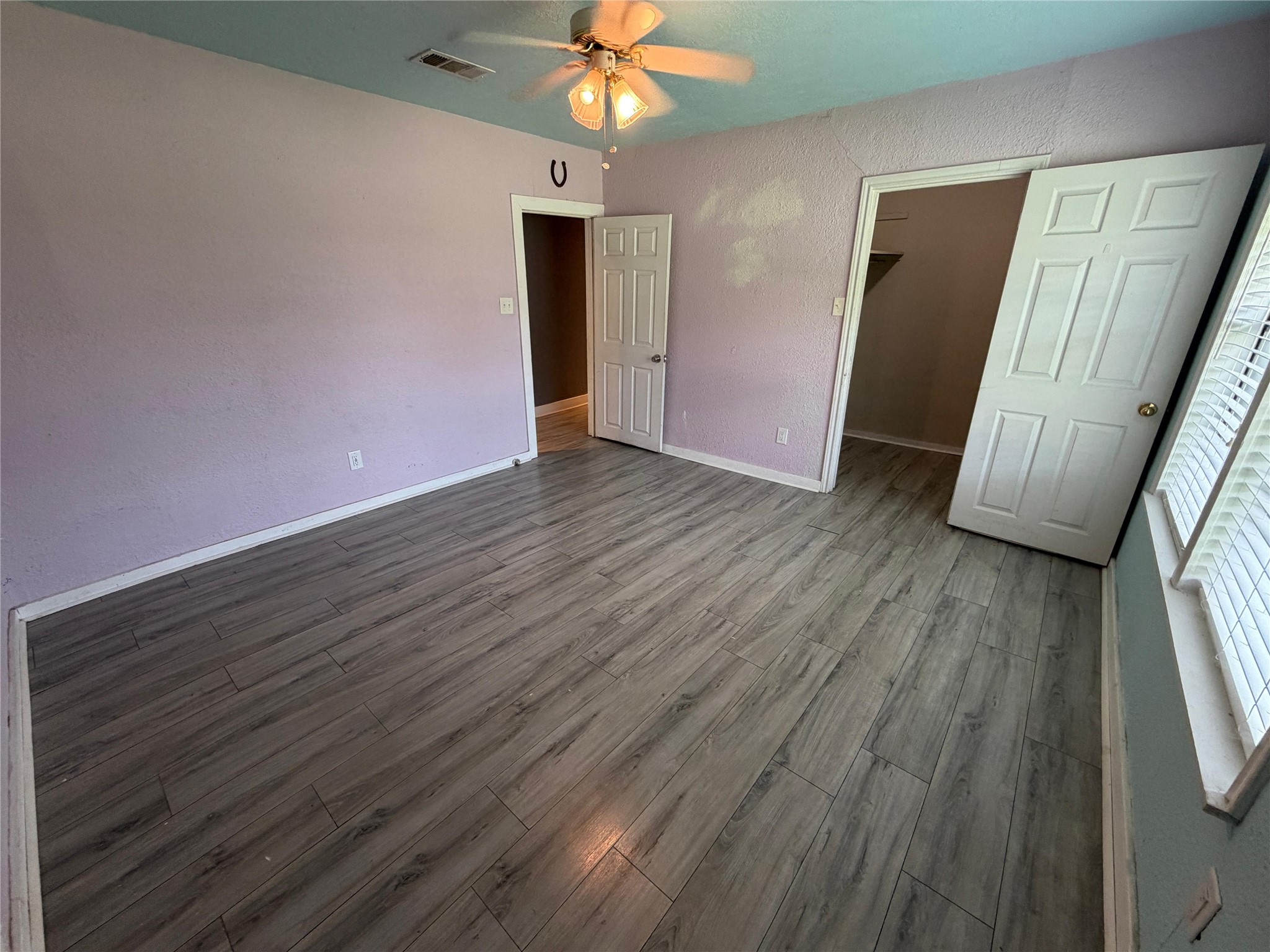 1401 East 29th Street Bryan, TX 77802 - Photo 4 of 13 A quiet bedroom featuring elegant wood plank flooring and a ceiling fan for comfort.