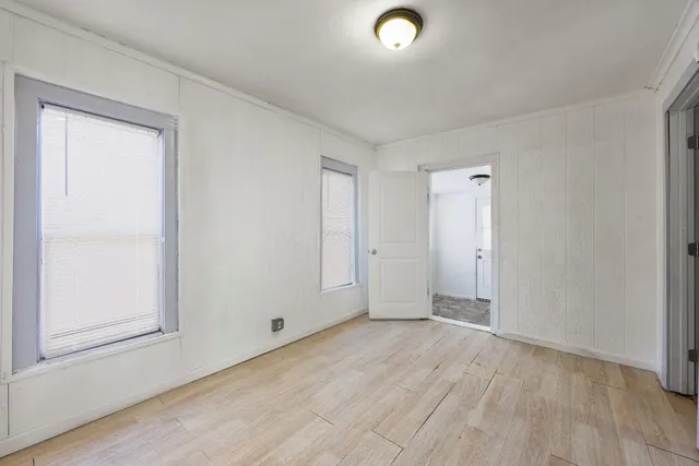 a view of a bedroom with wooden floor and closet