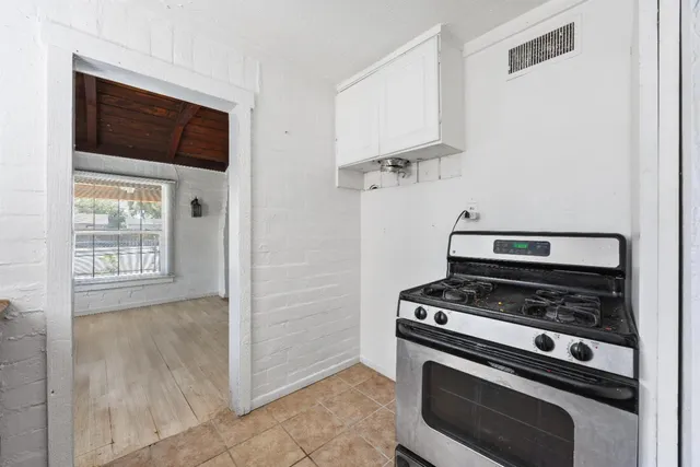 a view of a big room with wooden floor and a bathroom