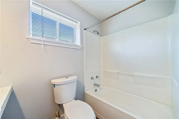 a white toilet and tub sitting next to a bathroom sink
