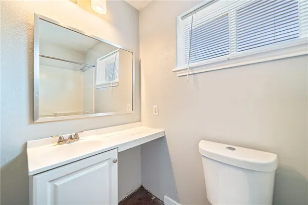 a bathroom with a sink a toilet and a mirror