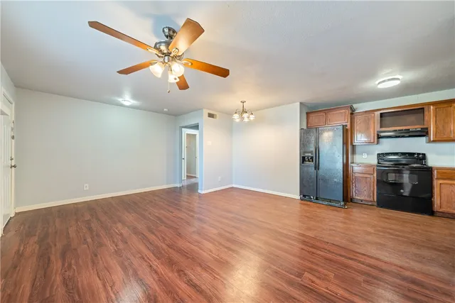 a view of a kitchen with a ceiling fan hardwood floor and a ceiling fan
