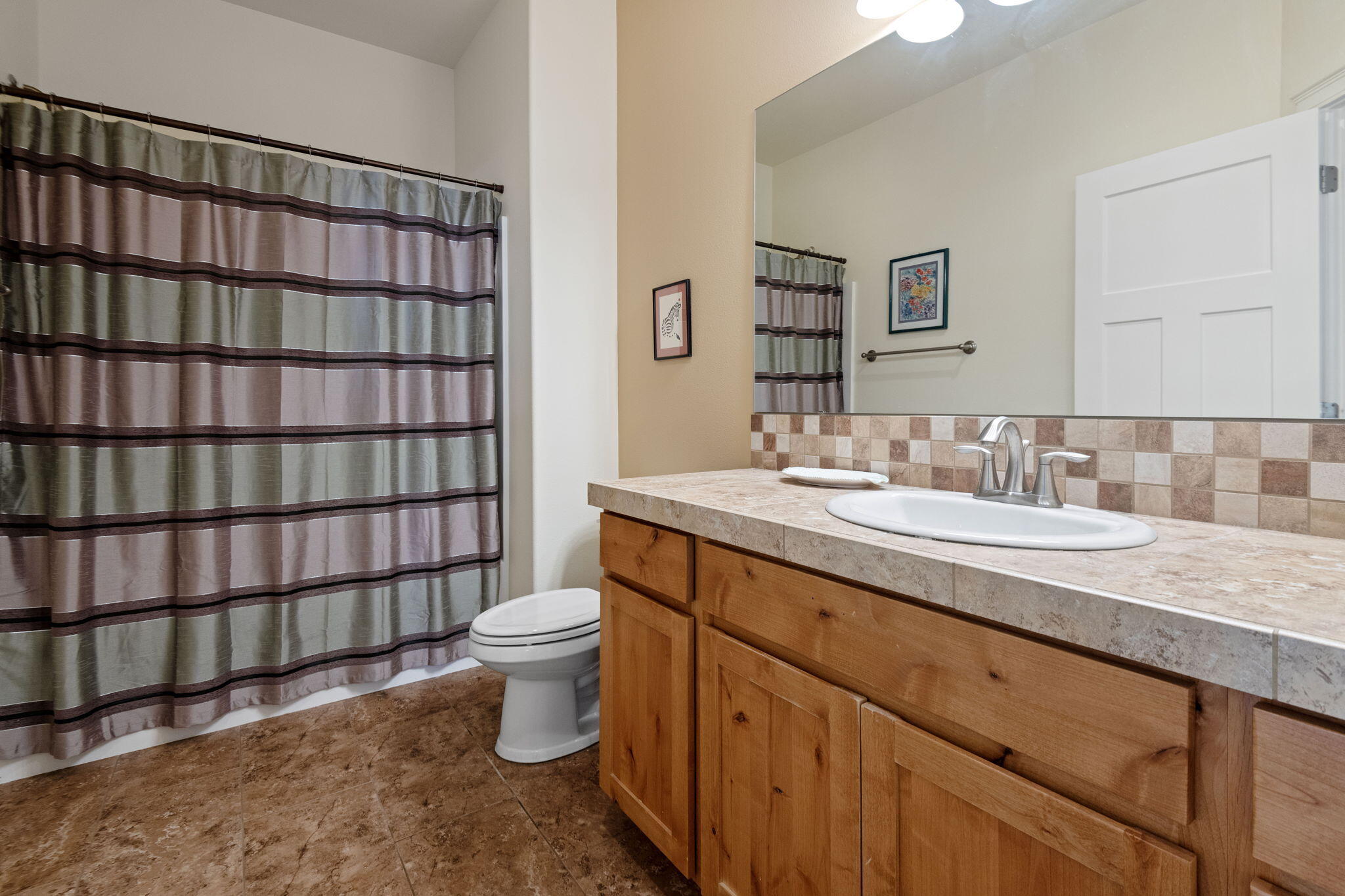 62944 Fresca Street Bend, OR 97703 - Photo 9 of 32 a bathroom with a granite countertop sink a toilet and a mirror