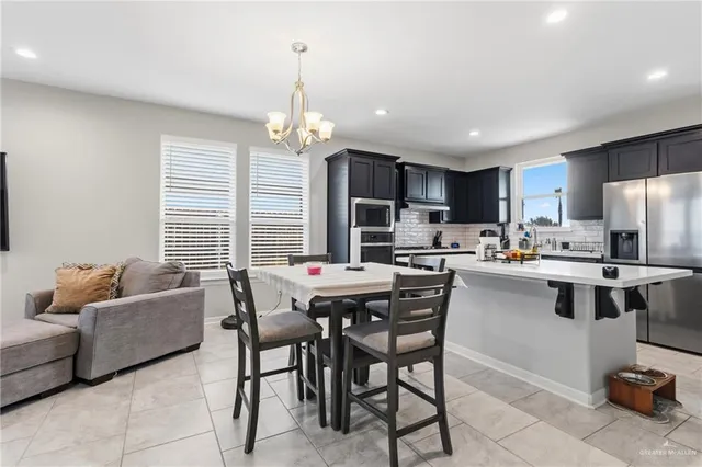 a kitchen with a dining table chairs and refrigerator