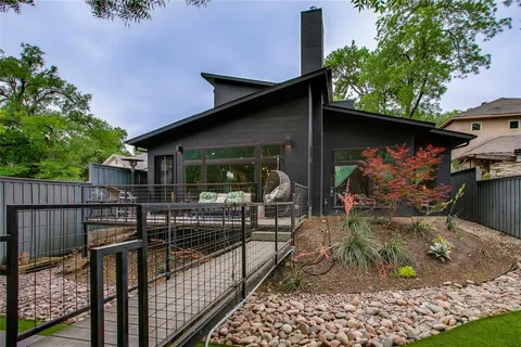 a view of a backyard with table and chairs plants and trees