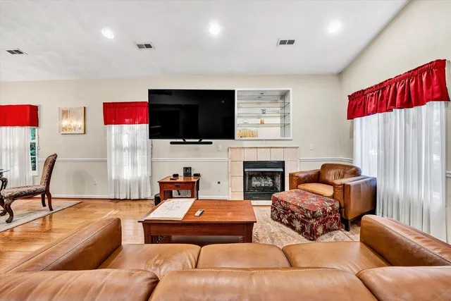 a living room with furniture a flat screen tv and a fireplace