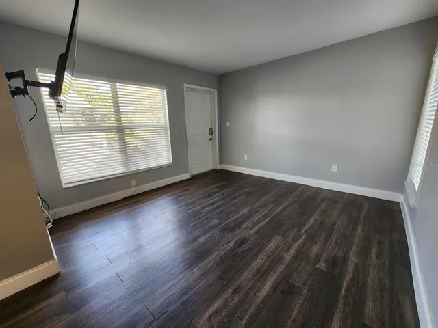 a view of empty room with wooden floor and window