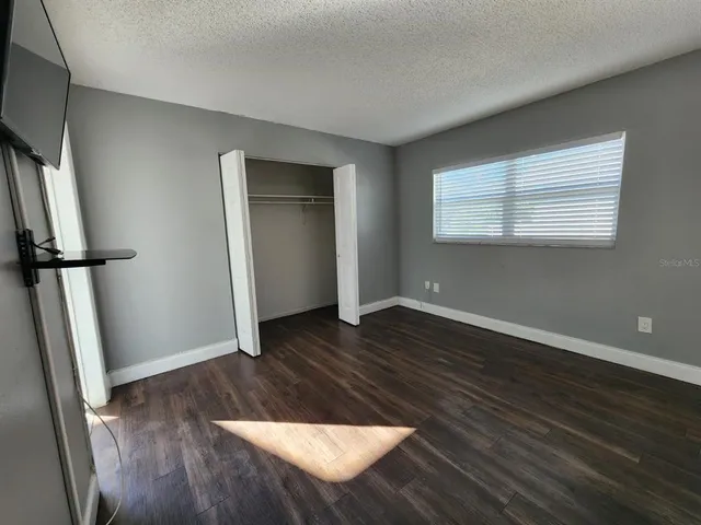 a view of a livingroom with wooden floor and a flat screen tv