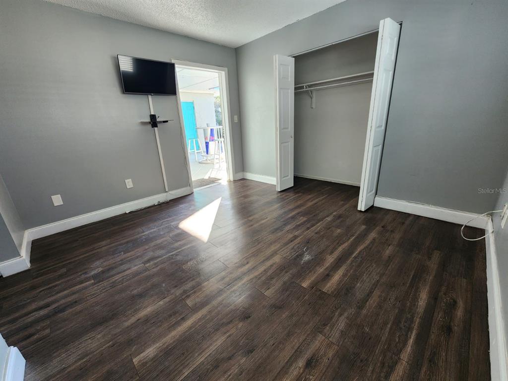 701 1st Street, Unit 4 Indian Rocks Beach, FL 33785 - Photo 6 of 10 a view of a livingroom with wooden floor and a flat screen tv