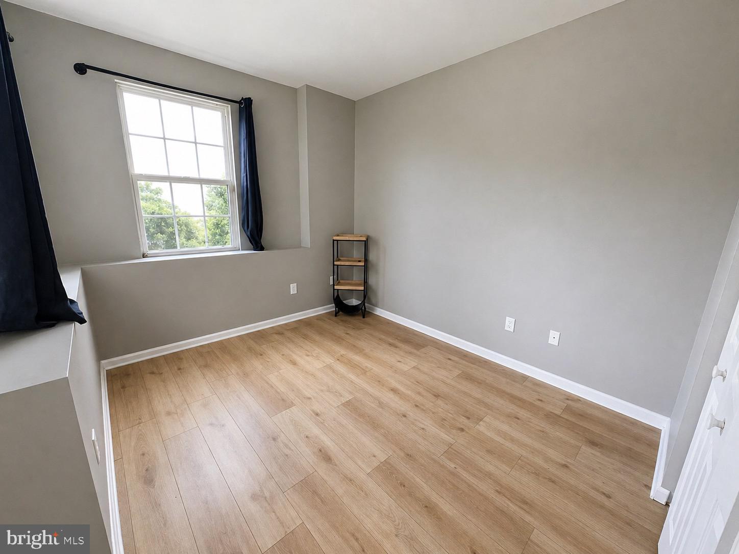 601 Forest Walk Lane, Unit 103 Odenton, MD 21113 - Photo 11 of 20 an empty room with wooden floor and windows