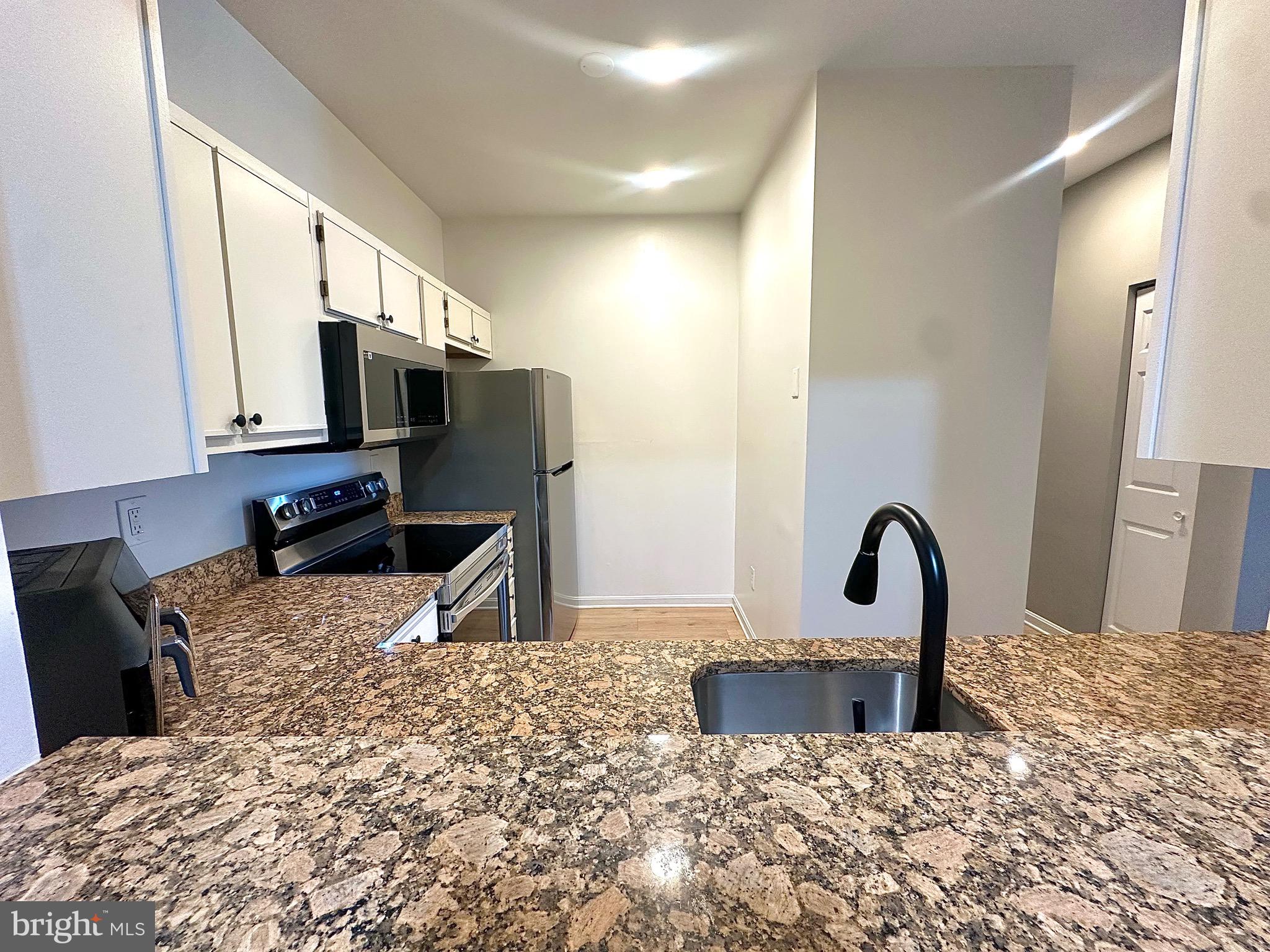 601 Forest Walk Lane, Unit 103 Odenton, MD 21113 - Photo 9 of 20 a close view of a sink a counter space and a refrigerator