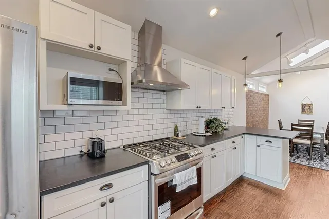 a kitchen with stainless steel appliances a sink stove and cabinets