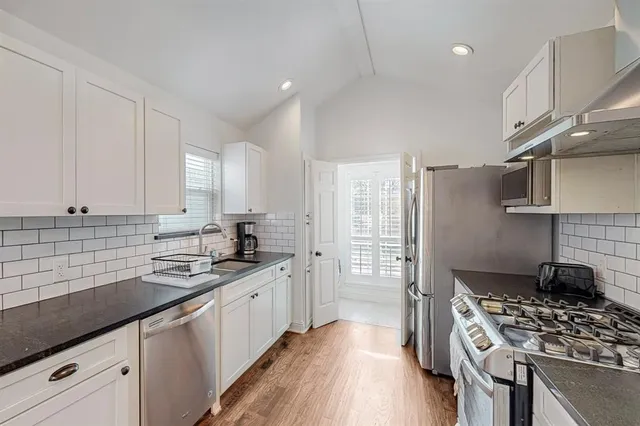 a kitchen with stainless steel appliances a sink stove and cabinets