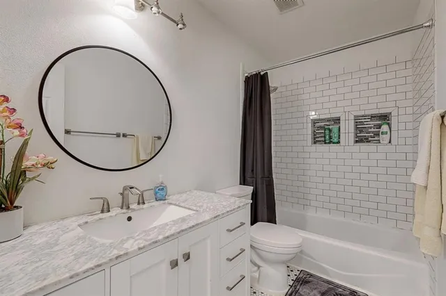 a bathroom with a sink a toilet and a mirror