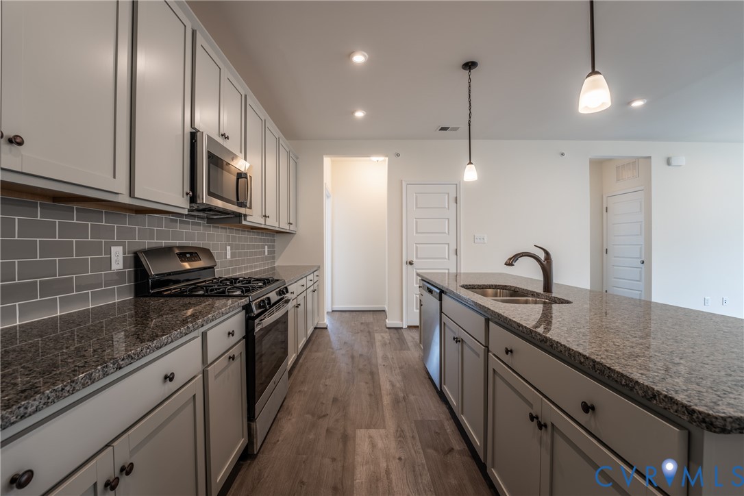 4003 Next Level Trace Midlothian, VA 23112 - Photo 8 of 38 a kitchen with stainless steel appliances granite countertop a sink a stove and a wooden floors