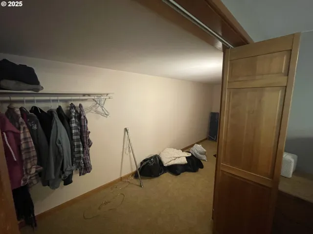 a view of walk in closet with clothes and shoes