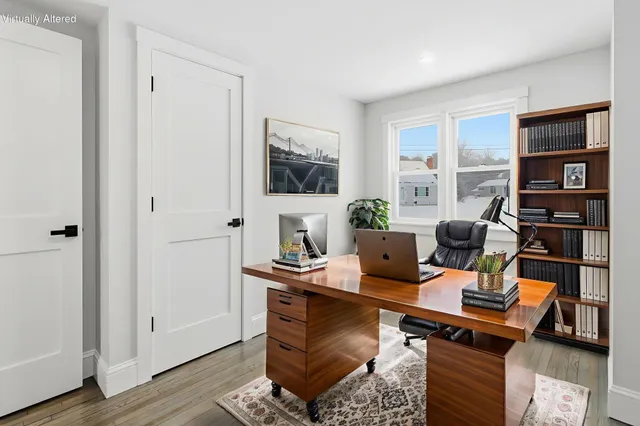 a work room with furniture a flat screen tv and a window