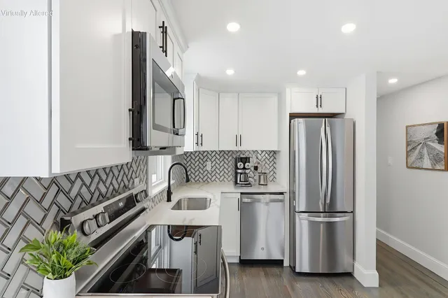 a kitchen with stainless steel appliances granite countertop a refrigerator a stove a sink and a stove