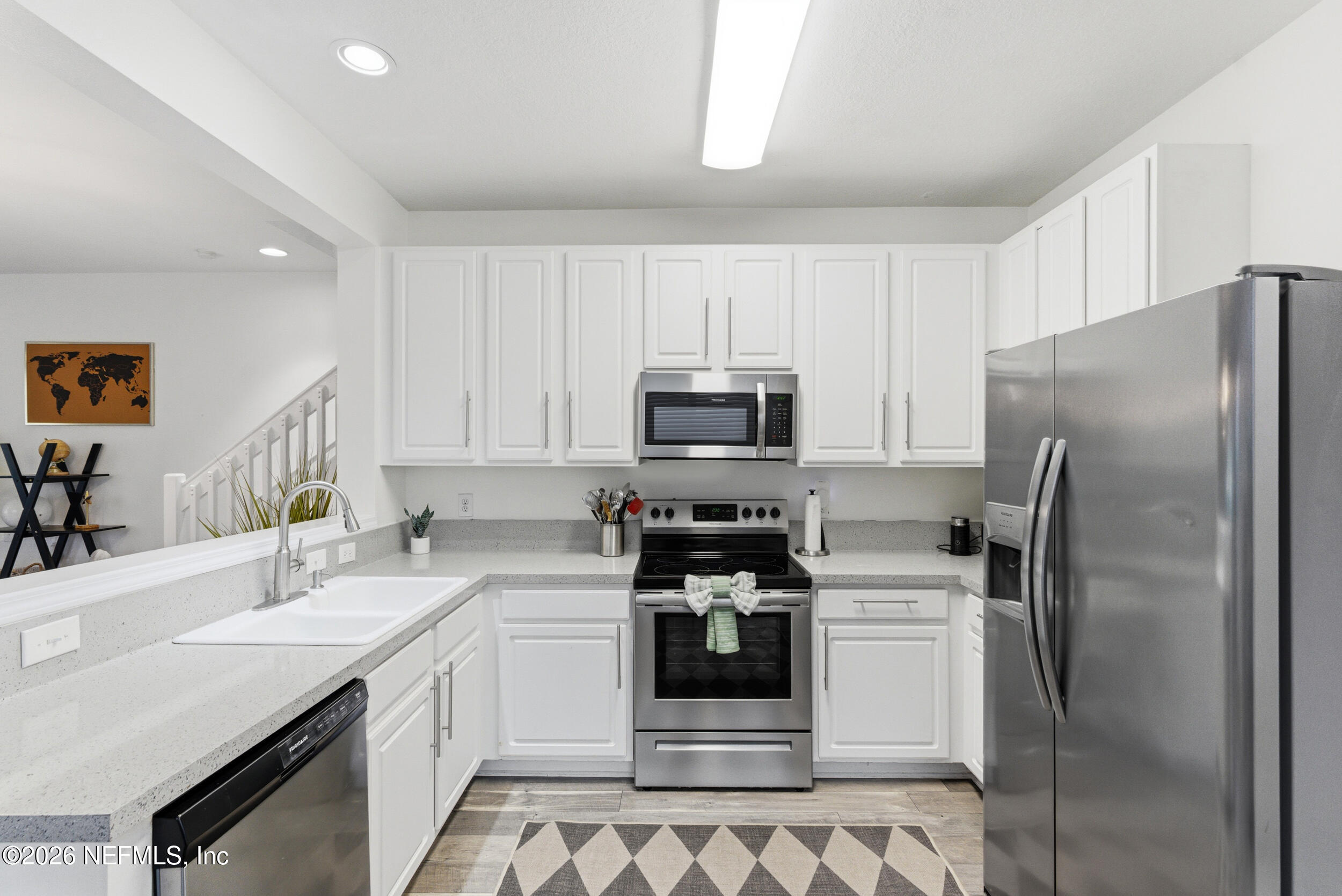 7990 Baymeadows Road, Unit 1801 Jacksonville, FL 32256 - Photo 11 of 48 a kitchen with stainless steel appliances a refrigerator sink and white cabinets
