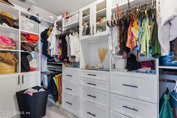 a view of walk in closet with clothes and shoes