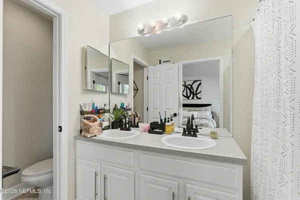 a bathroom with a sink a toilet and a mirror