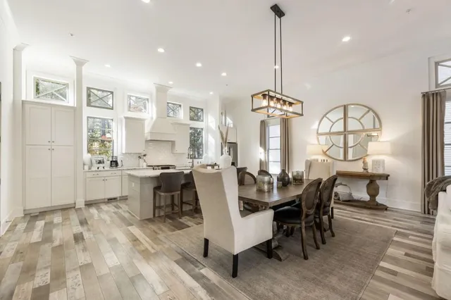 a view of a dining room with furniture a chandelier and wooden floor
