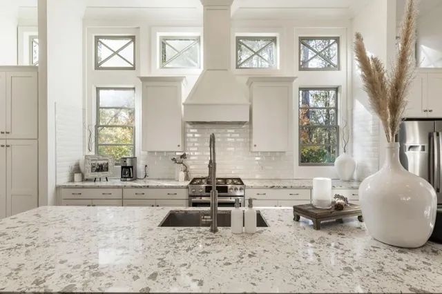 a kitchen with stainless steel appliances kitchen island granite countertop a stove a sink and a granite counter tops