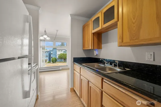 a kitchen with granite countertop a sink and a refrigerator