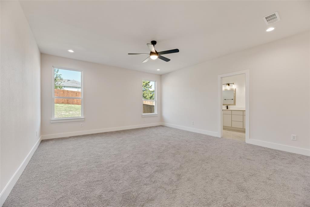 6046 Plum Dale Road Dallas, TX 75241 - Photo 12 of 27 an empty room with windows and fan